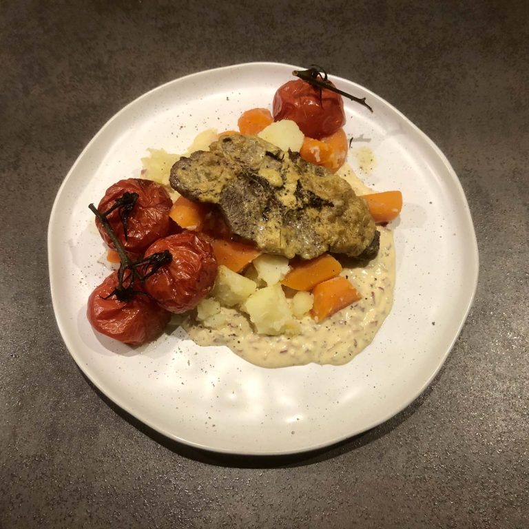 Lamskotelet met rozemarijn, aardappelen en wortelen, gepofte tomaatjes en mosterdsaus