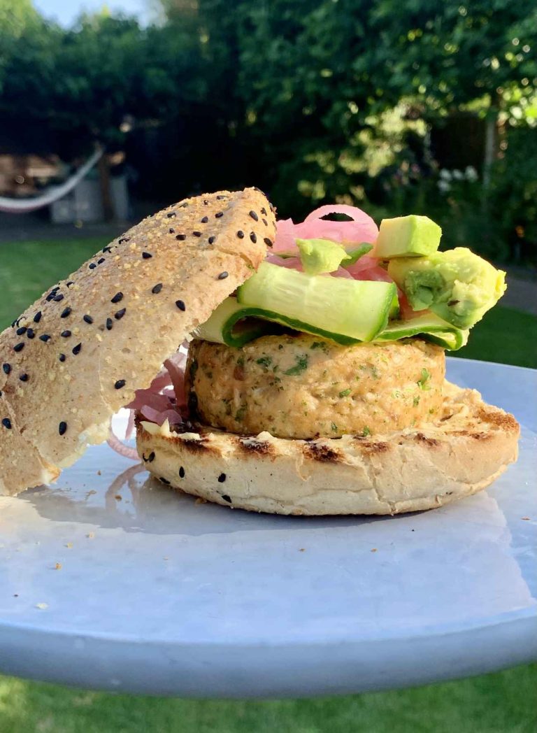 Gezonde zalmburger met ingelegde rode ui, avocado, komkommer en citroenmayo